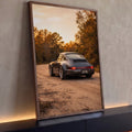 Porsche 911 cinza de traseira em estrada de terra com árvores de outono ao pôr do sol, quadro decorativo