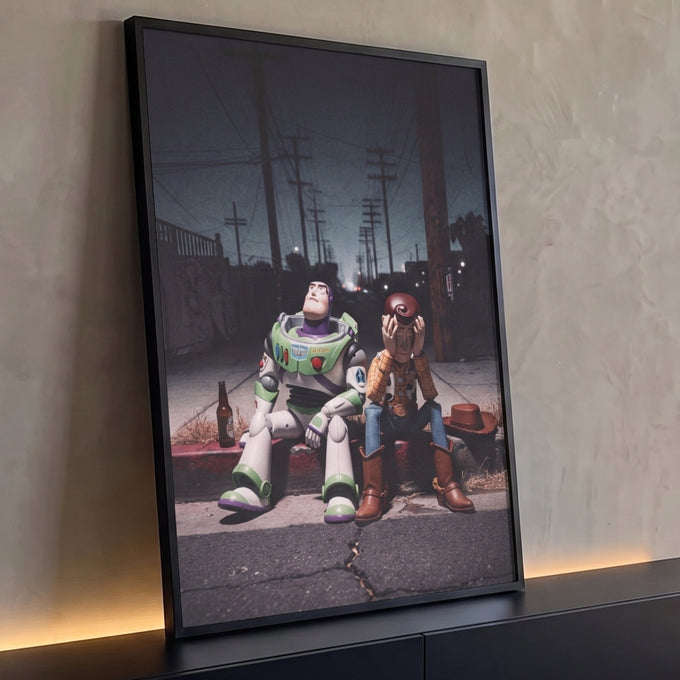 Bonecos de caubói e astronauta sentados no meio-fio de rua noturna com postes, quadro decorativo
