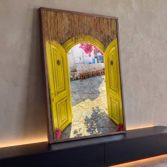 Porta amarela em arco com teto de palha, pátio de pedra e buganvílias rosa em vila grega, quadro decorativo