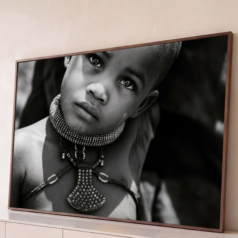 Criança africana Himba com colar tribal de contas e olhar intenso em fotografia preto e branco, quadro decorativo
