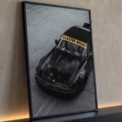 Porsche 911 RWB preto visto de cima sobre concreto cinza, faixa Rauh-Welt no para-brisa, quadro decorativo