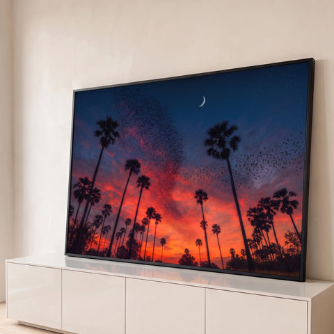 Palmeiras em silhueta sob céu laranja de pôr do sol com revoada de pássaros e lua, quadro decorativo