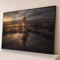 Filhote de leão na savana de terra rachada vendo o reflexo de um leão adulto na água, quadro decorativo
