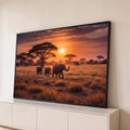 Quadro Decorativo Grande Elefantes Pôr do Sol para Sala | quadros decorativos para sala | três elefantes caminhando na savana africana sob um pôr do sol alaranjado | Porao dos Quadros