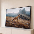 Raposa vermelha em campo de grama seca com picos rochosos das montanhas ao fundo, quadro decorativo