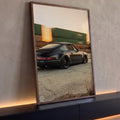 Porsche 911 preto rebaixado com rodas raiadas e trem de carga borrado ao pôr do sol, quadro decorativo