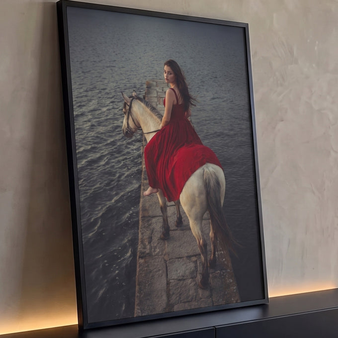 Mulher de vestido vermelho montada em cavalo branco sobre cais de pedra e água escura, quadro decorativo
