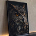 Coruja em close de perfil com olhos laranja e penas marrons sobre fundo escuro, quadro decorativo