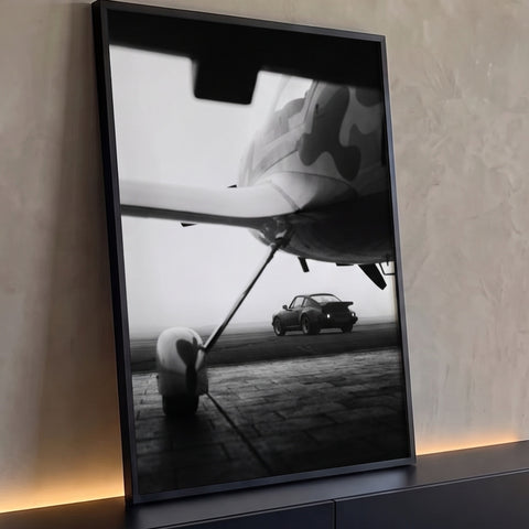 Porsche 911 clássico na pista vista sob asa de avião camuflado em névoa, foto P&B, quadro decorativo