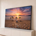 Praia ao pôr do sol com guarda-sóis, barcos, conchas, estrela-do-mar e garrafa na areia, quadro decorativo