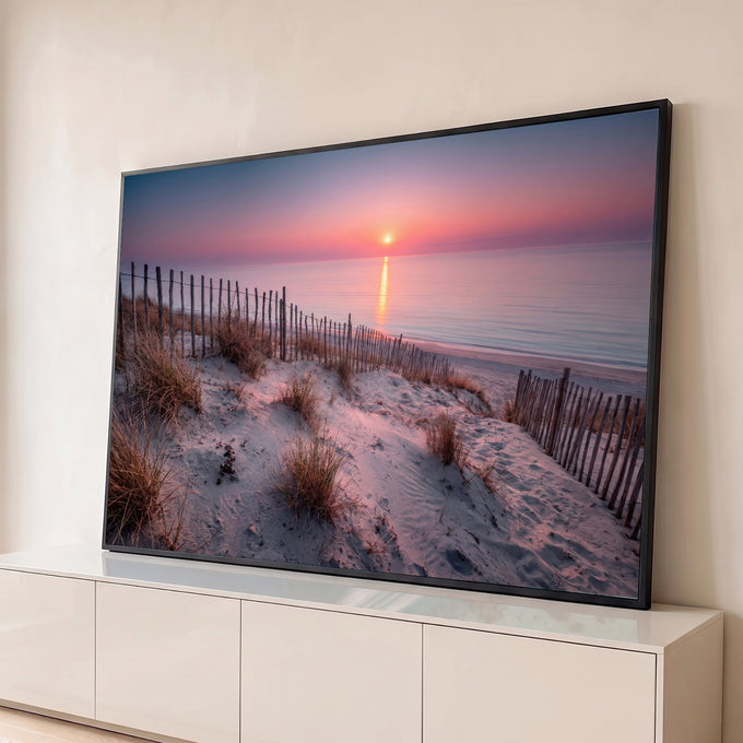 Pôr do sol rosa sobre o mar com dunas de areia, capim e cerca de madeira na praia, quadro decorativo