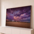 Quadro Decorativo Grande Céu de Tempestade para Sala Roxo | quadros decorativos para sala | céu roxo dramático de tempestade sobre praia com casas e pessoas distantes | Porao dos Quadros