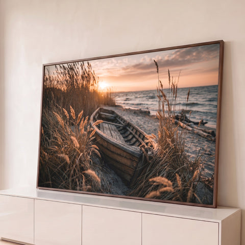Barco de madeira antigo na areia da praia entre capim dourado ao pôr do sol, quadro decorativo
