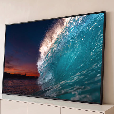 Onda do mar turquesa formando tubo com espuma brilhante e céu de pôr do sol ao fundo, quadro decorativo