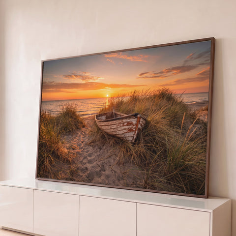 Barco de madeira antigo entre a vegetação da duna, praia e mar ao pôr do sol laranja, quadro decorativo