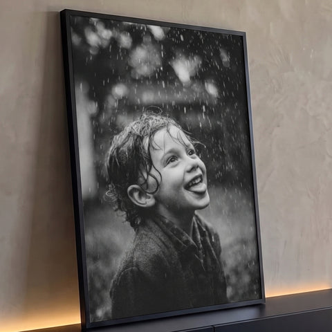 Garoto molhado sorrindo com a língua de fora sob gotas de chuva em preto e branco, quadro decorativo
