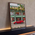 Carro esportivo vermelho clássico em frente a fachada verde com palmeira e flores, quadro decorativo