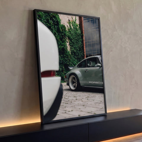 Porsche clássico verde-oliva junto a muro de tijolos com hera em rua de pedras, quadro decorativo