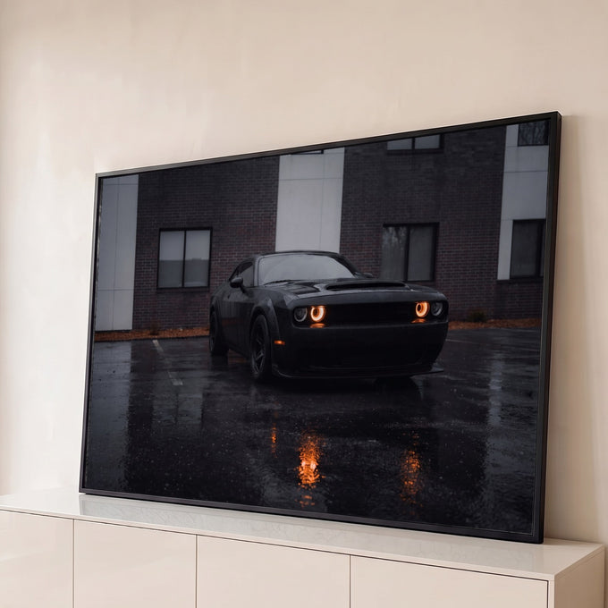 Carro esportivo preto com faróis laranja acesos em estacionamento molhado pela chuva, quadro decorativo