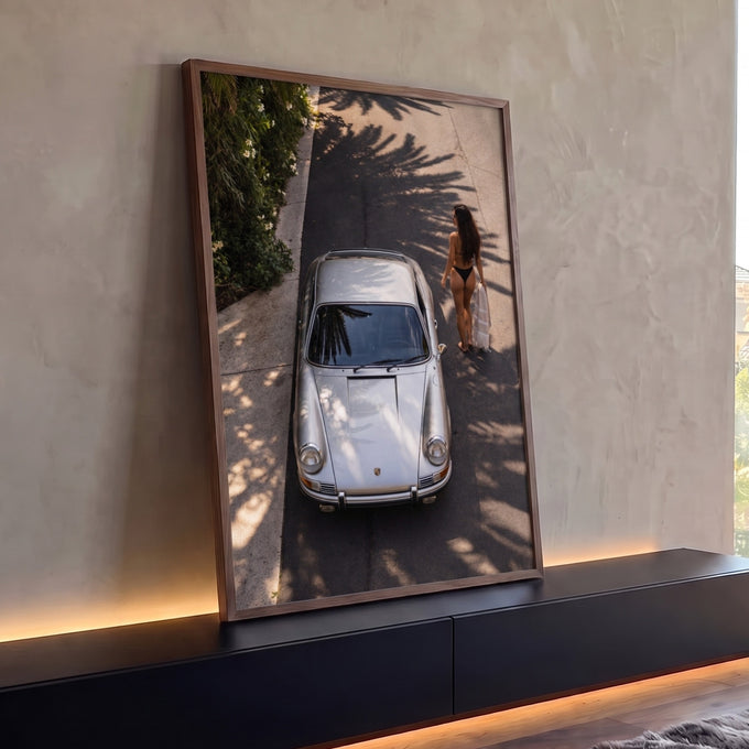 Porsche 911 prata visto do alto com mulher de biquíni e sombras de palmeiras no asfalto, quadro decorativo