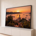 Quadro Decorativo Grande Farol ao Pôr do Sol para Sala | quadros decorativos para sala | farol branco entre veleiros em baía ao pôr do sol laranja | Porao dos Quadros