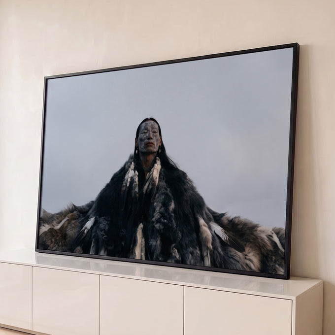 Xamã indígena de rosto pintado com manto de peles e penas sob céu cinza nublado, quadro decorativo