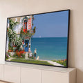 Quadro Decorativo Grande Café à Beira Mar para Sala Azul | quadros decorativos para sala | fachada de café litorâneo com flores, homem e cachorro observando o mar | Porao dos Quadros