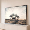 Três cavaleiras saltam a cavalo sobre um Porsche clássico no deserto, contra a luz do sol, quadro decorativo
