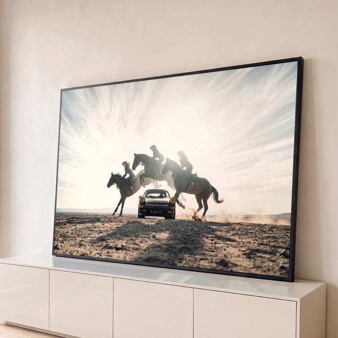 Três cavaleiras saltam a cavalo sobre um Porsche clássico no deserto, contra a luz do sol, quadro decorativo
