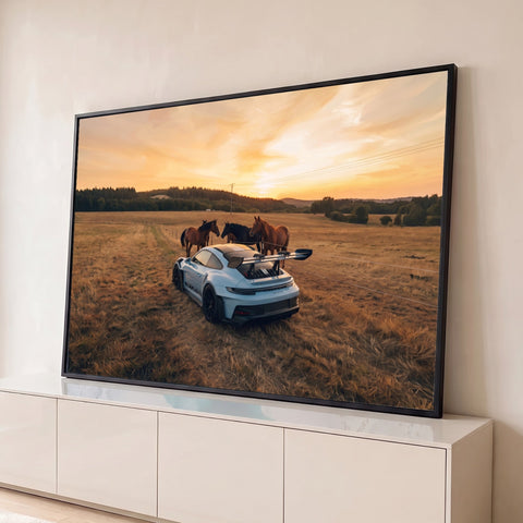 Porsche GT3 RS branco em campo dourado com três cavalos e céu laranja ao pôr do sol, quadro decorativo