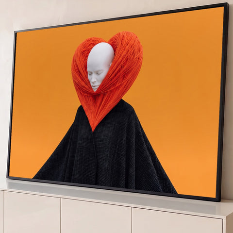 Rosto branco de olhos fechados dentro de coração de fios laranja, manto preto e fundo laranja, quadro decorativo