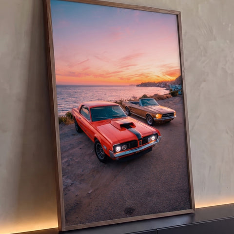 Dois carros clássicos, laranja e dourado conversível, à beira-mar ao pôr do sol, quadro decorativo