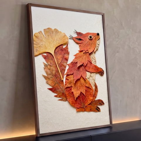 Esquilo montado com folhas secas de bordo e ginkgo em tons laranja sobre fundo creme, quadro decorativo