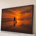 Quadro Decorativo Grande Casal e Cachorro para Sala Laranja | quadros decorativos para sala | casal abraçado e cachorro na praia durante pôr do sol laranja com veleiros ao fundo | Porao dos Quadros