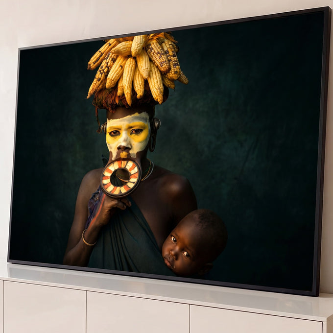 Quadro Decorativo Grande Mulher Africana Preto para Sala | quadros decorativos para sala | mulher africana com prato labial, pintura facial e milho sobre a cabeça carregando bebê | Porao dos Quadros