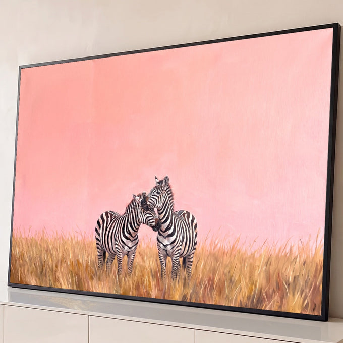 Pintura a óleo de duas zebras abraçadas no capim dourado sob céu rosa, quadro decorativo