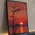 Corvos em silhueta numa árvore seca diante do pôr do sol vermelho refletido no mar, quadro decorativo