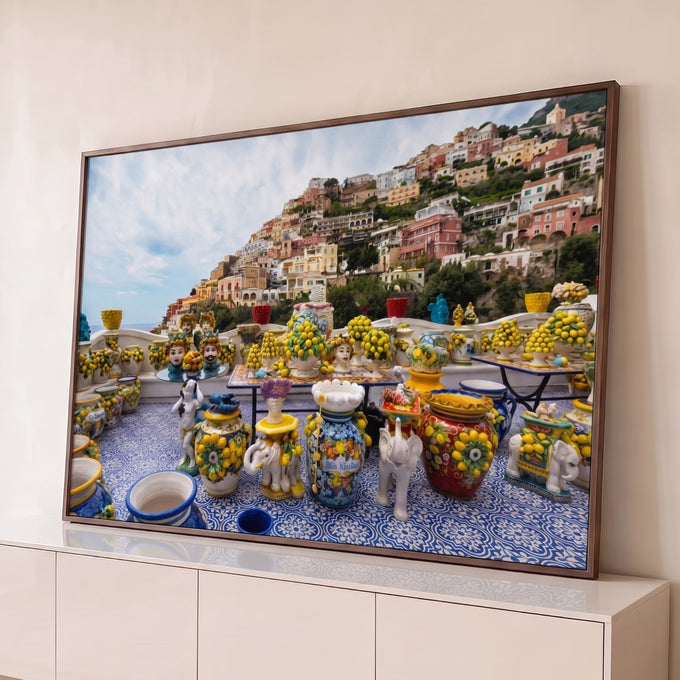 Vasos de cerâmica com limões em terraço de azulejo azul e a vila colorida de Positano ao fundo, quadro decorativo