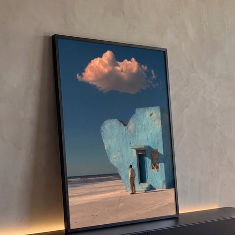 Casa azul em formato de coração na praia com homem, gato laranja e nuvem rosada, quadro decorativo