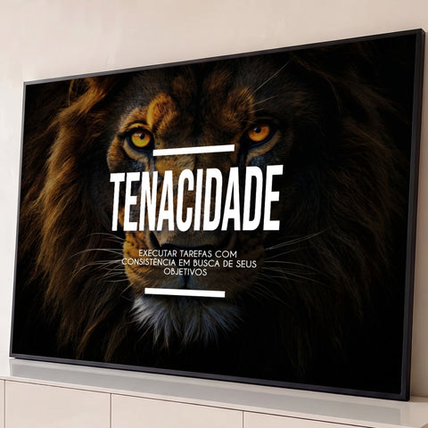 Rosto de leão com olhos âmbar em fundo escuro e a palavra Tenacidade em letras brancas, quadro decorativo