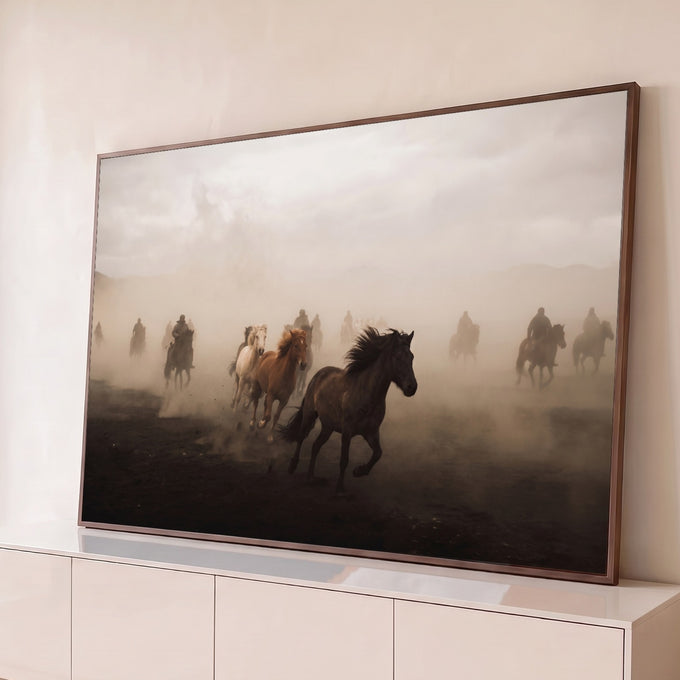 Cavalos galopando em meio à poeira com cavaleiros ao fundo em tons de bege e sépia, quadro decorativo