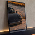 Quadro Decorativo Grande Carro Esportivo Preto para Sala | quadros decorativos para sala | carro esportivo cinza escuro com farol redondo em cenário de areia ao entardecer | Porao dos Quadros