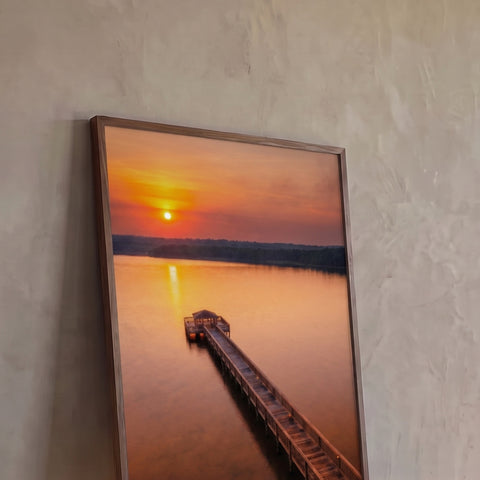 Vista aérea de píer de madeira com quiosque em lago calmo ao pôr do sol laranja, quadro decorativo
