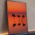 Quadro Decorativo Grande Flamingos em Silhueta para Sala | quadros decorativos para sala | três flamingos em silhueta contra céu laranja de pôr do sol refletidos na água | Porao dos Quadros