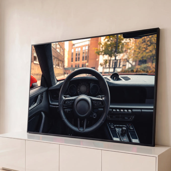 Interior de carro esportivo com volante de couro preto, painel e rua urbana de outono ao fundo, quadro decorativo