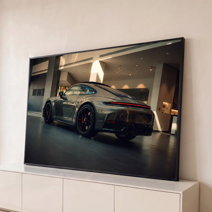 Porsche 911 cinza em showroom iluminado, lanterna vermelha e rodas pretas, quadro decorativo