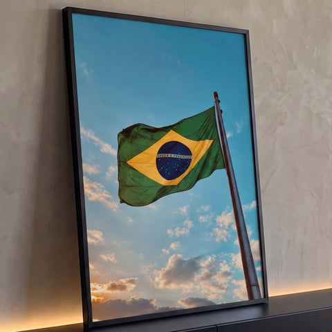 Bandeira do Brasil tremulando no mastro contra céu azul com nuvens ao entardecer, quadro decorativo