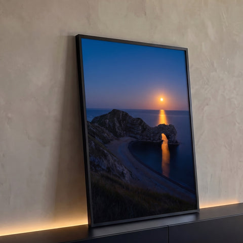 Arco de pedra sobre praia deserta com lua cheia refletindo no mar azul ao anoitecer, quadro decorativo