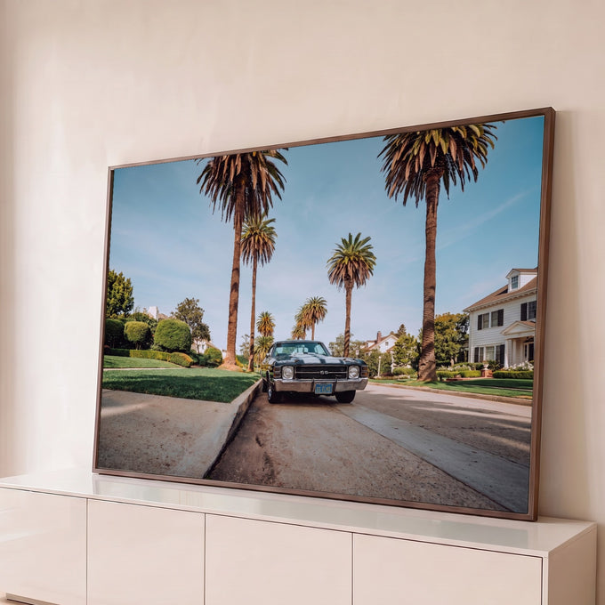 Chevelle SS preto com faixas brancas em rua com palmeiras altas e céu azul, fotografia quadro decorativo