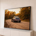 Porsche 911 cinza em estrada de terra entre árvores de outono ao pôr do sol, quadro decorativo